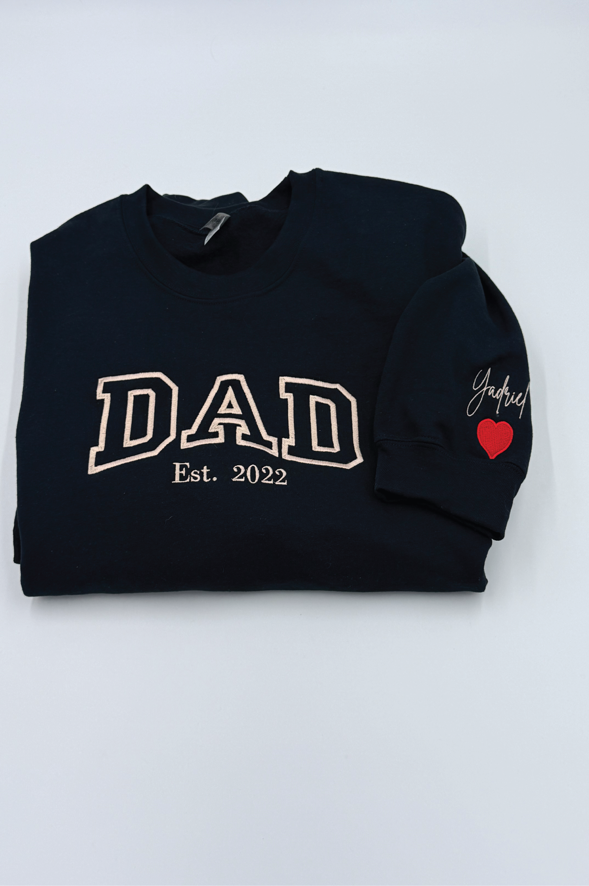 Black sweatshirt with 'DAD Est. 2022' text and a red heart on a white background
