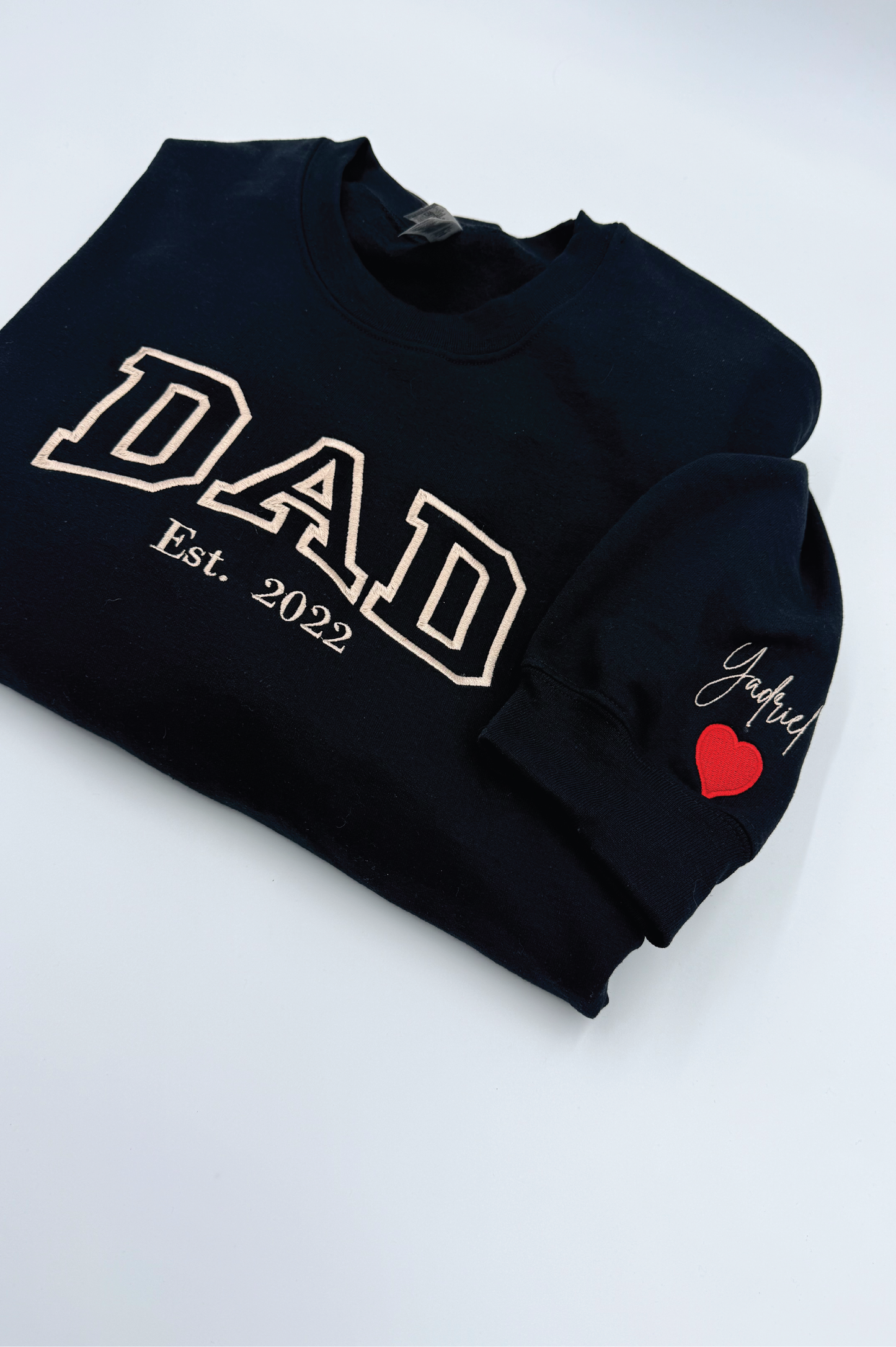 Black sweatshirt with 'DAD Est. 2022' text and a red heart on a white background