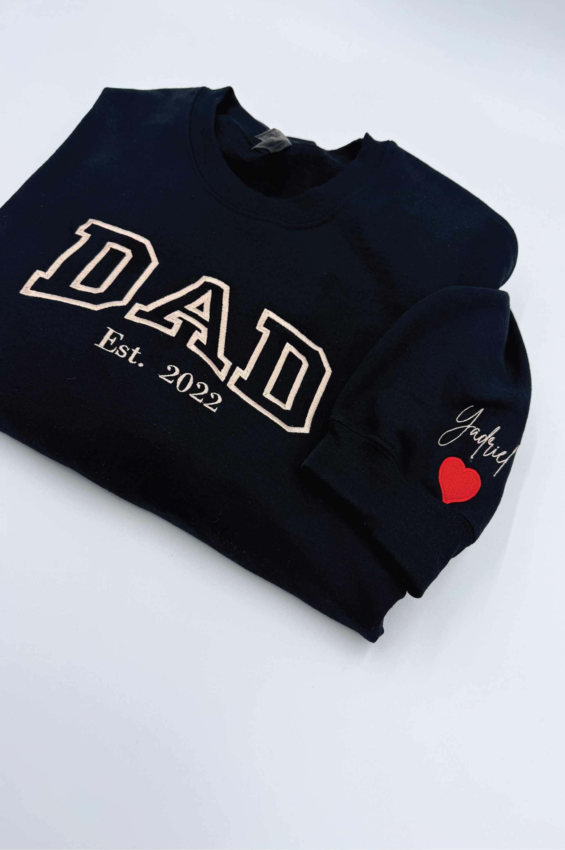 Black sweatshirt with 'DAD Est. 2022' text and a red heart on a white background