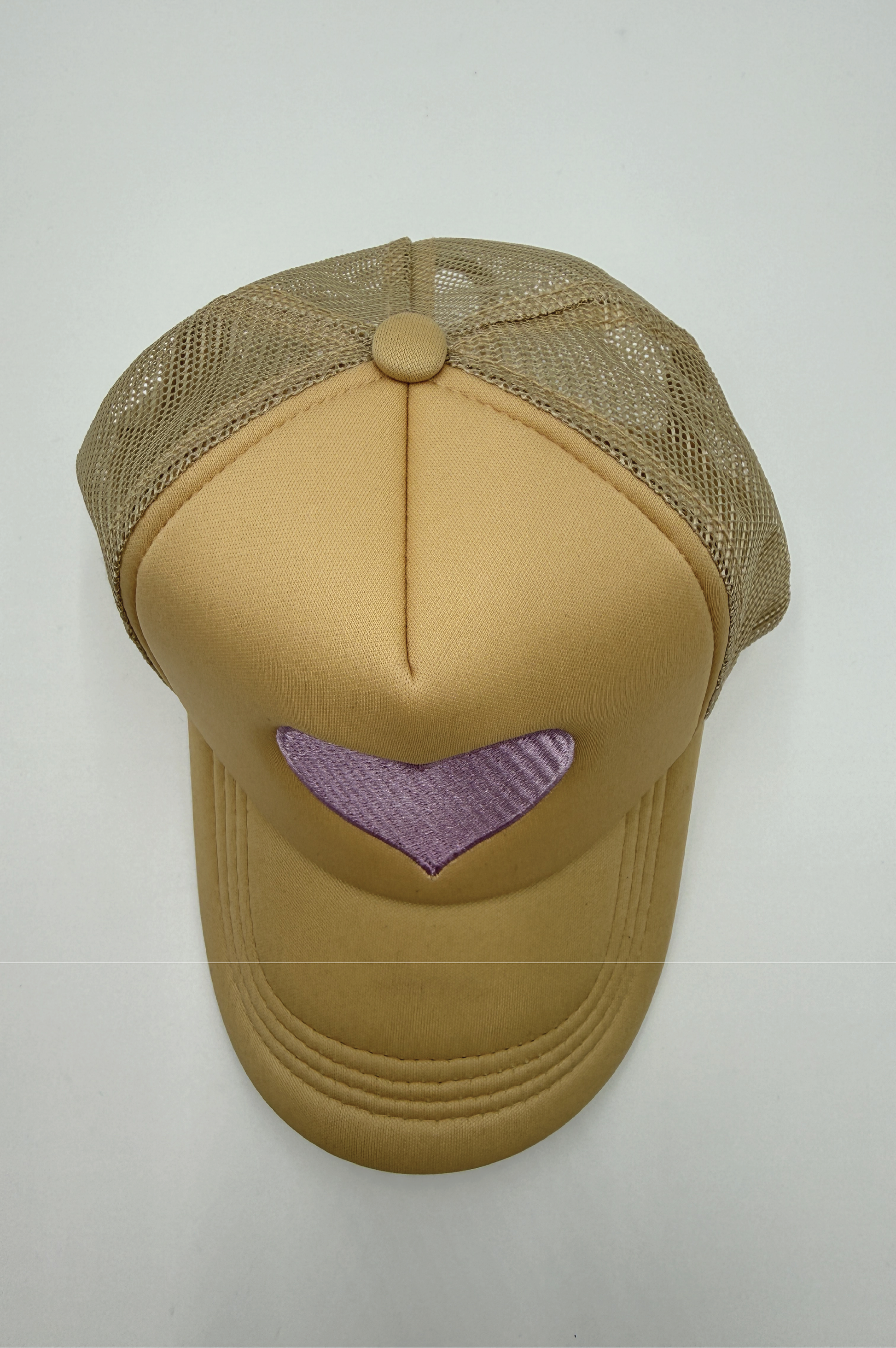 Beige baseball cap with a heart-shaped cutout on a white background